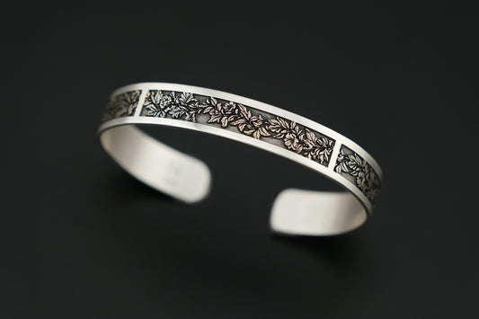 Silver bracelet with intricate design on a black background